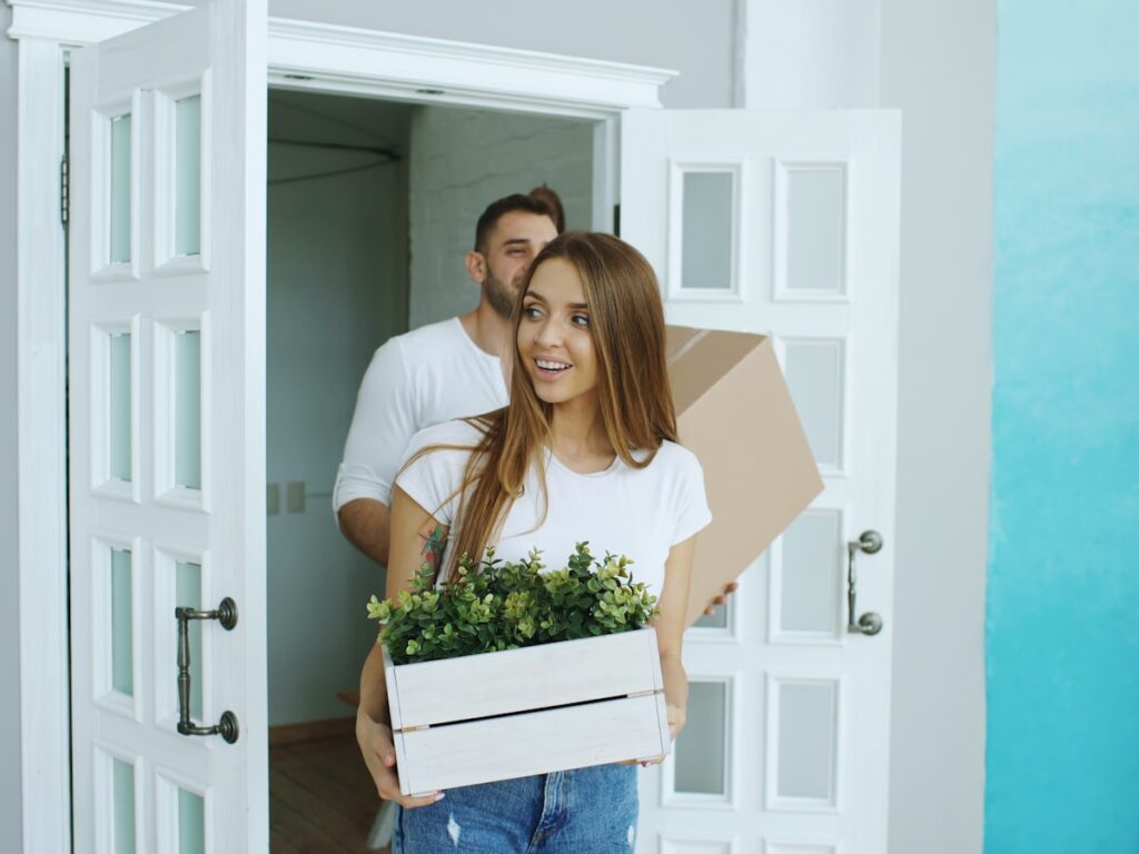 Paar traegt Umzugskartons in die neue Wohnung in Waiblingen